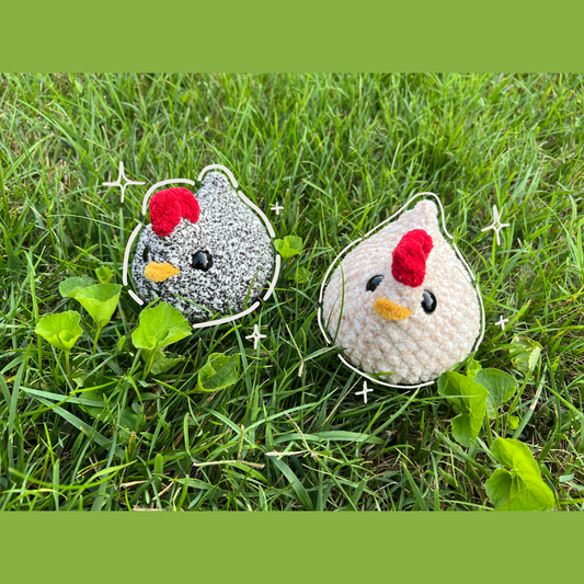 two crochet chickens sitting in grass