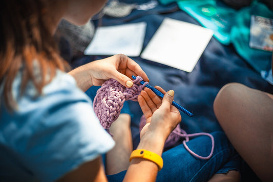 Hands holding yarn and a crochet hook