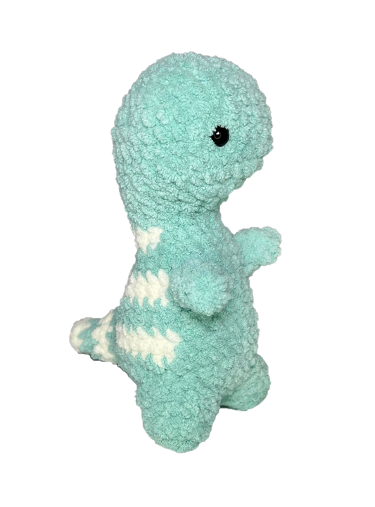 Green crochet dinosaur looking right.