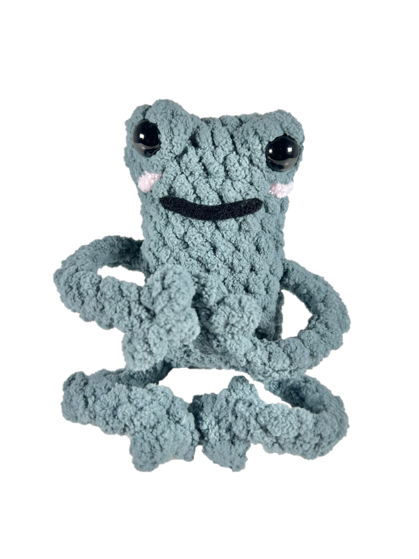 Green crochet frog in yoga pose.