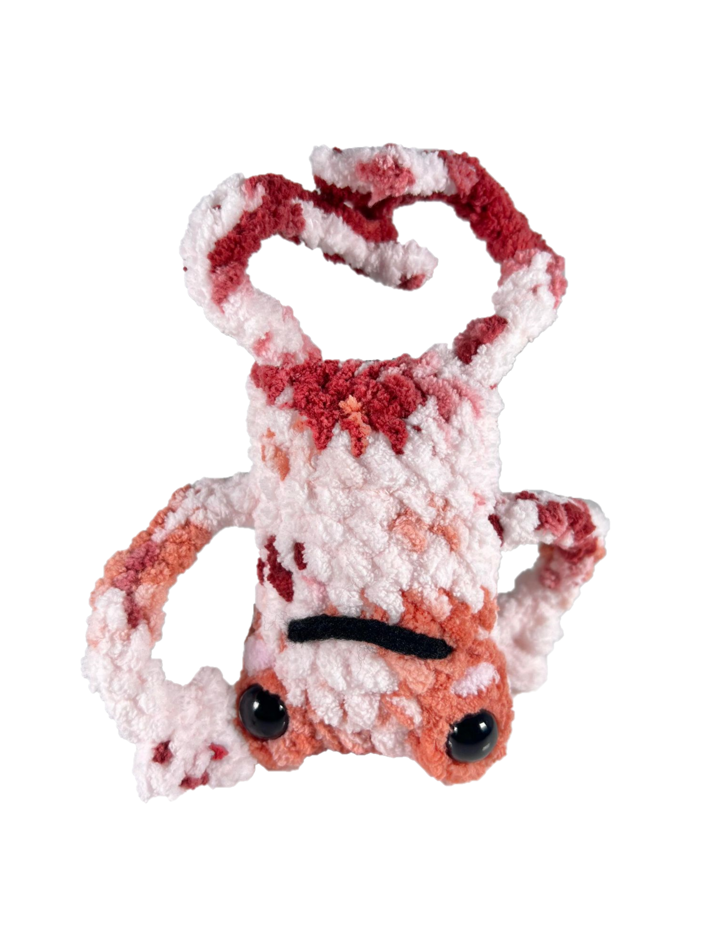 White crochet frog plushie with multiple colors mixed in such as orange and red, and doing a head spin pose.