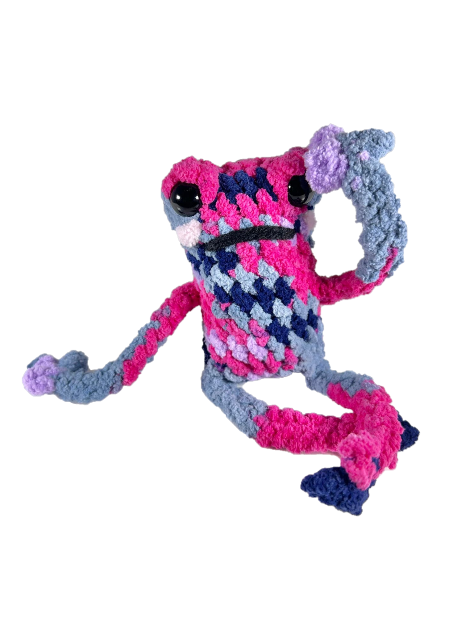 Dramatic multicolored crochet frog plushie in dramatic pose.