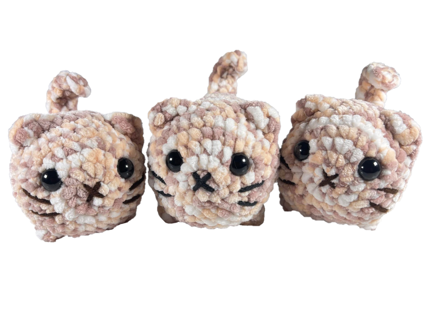 Three brown and white mixed color crochet loaf cat plushies.