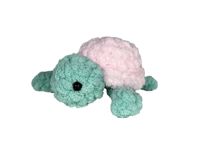 Green crochet turtle with a pink shell.