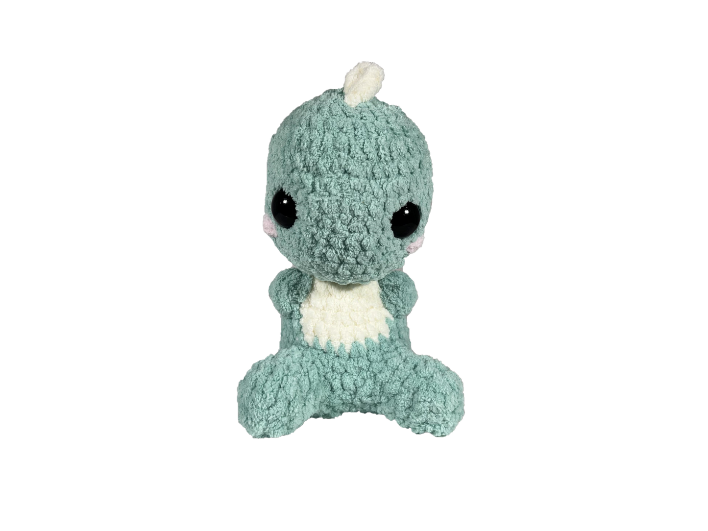 Green crochet dinosaur with soft spikes on its head and back looking forward.