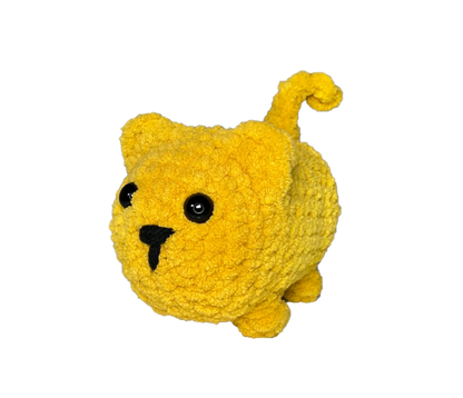 Chunky yellow crochet cat standing on four legs.